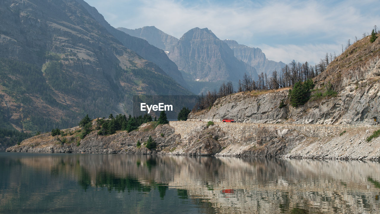 Scenic view of lake by mountains against sky