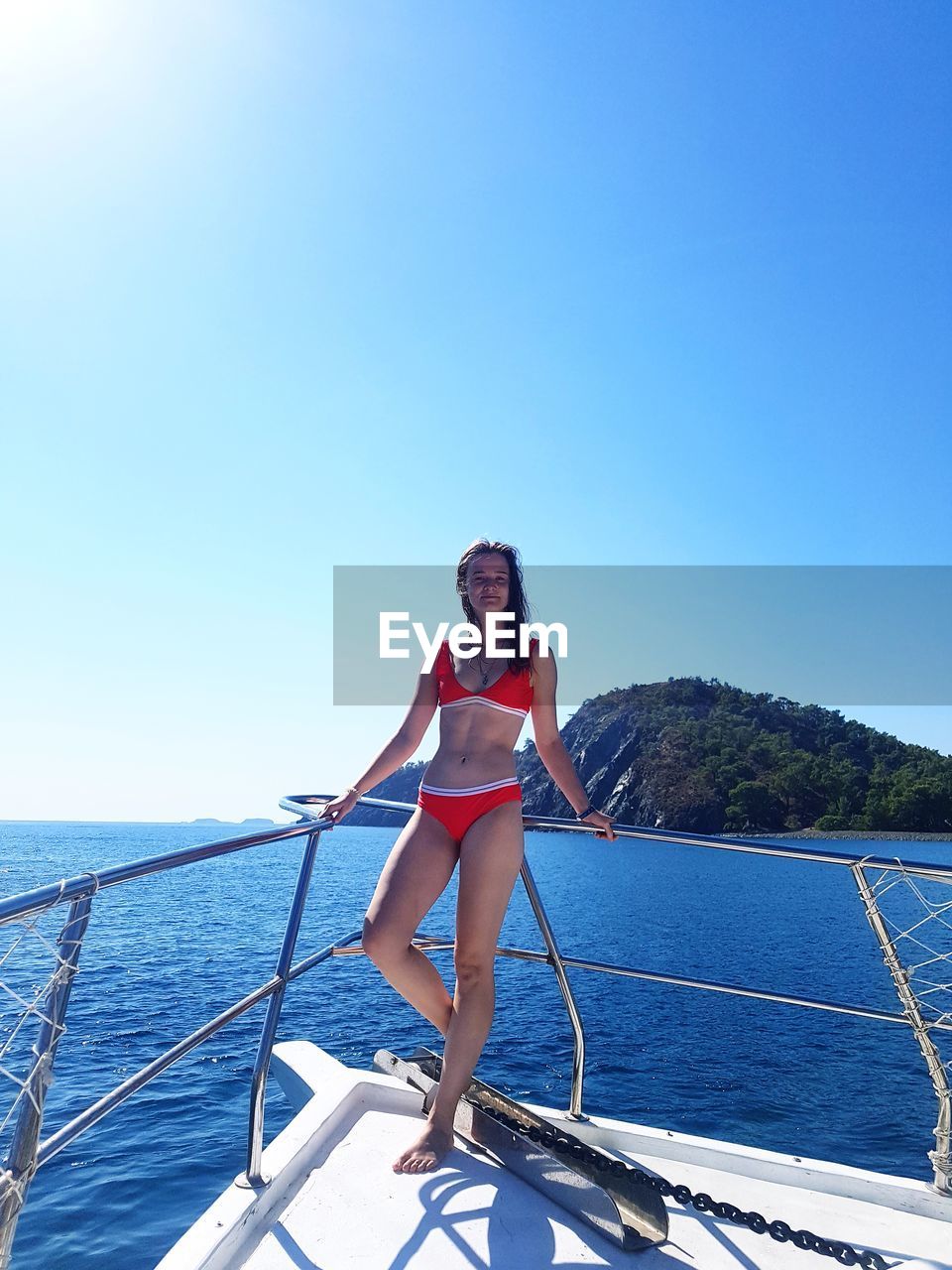 full length of young woman standing against clear sky