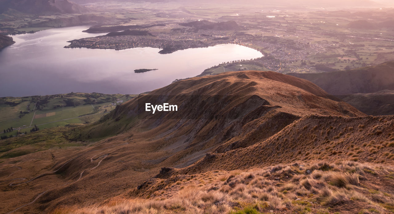 View on valley with lake during sunrise. shot made on roys peak summit in wanaka, new zealand