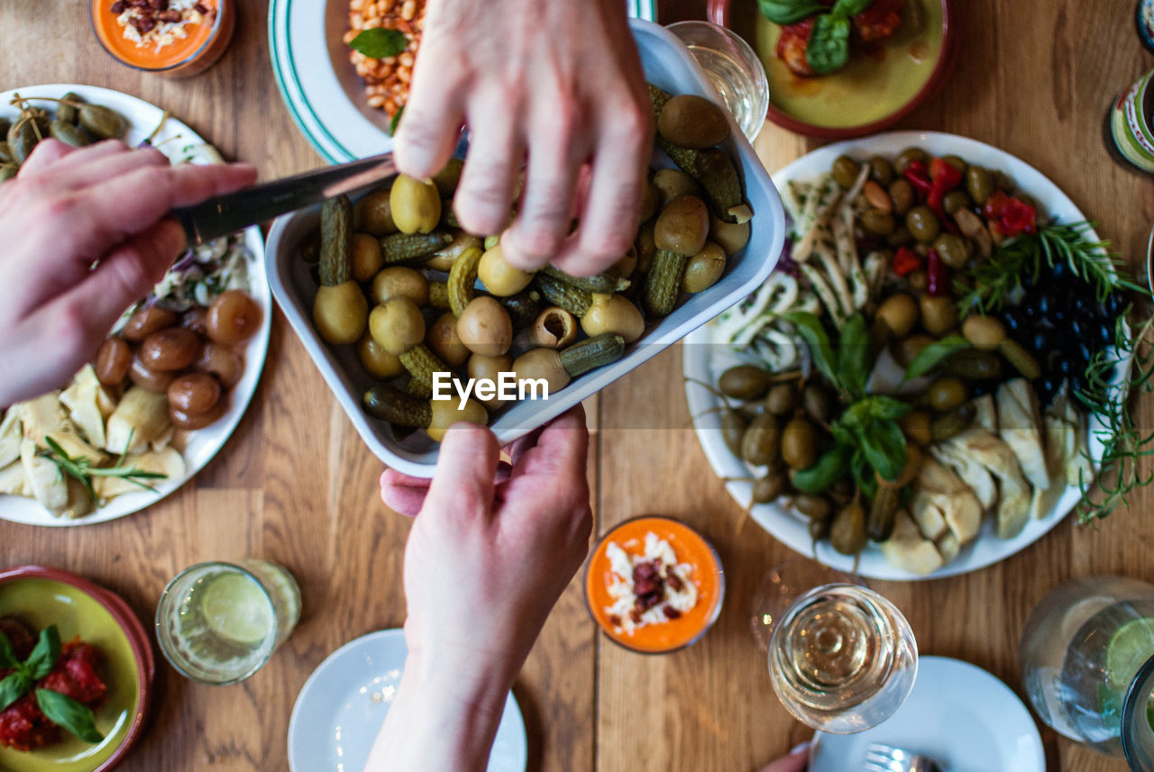 Cropped image of hands with food served on table