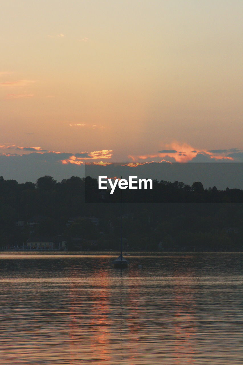 Scenic view of lake against orange sky