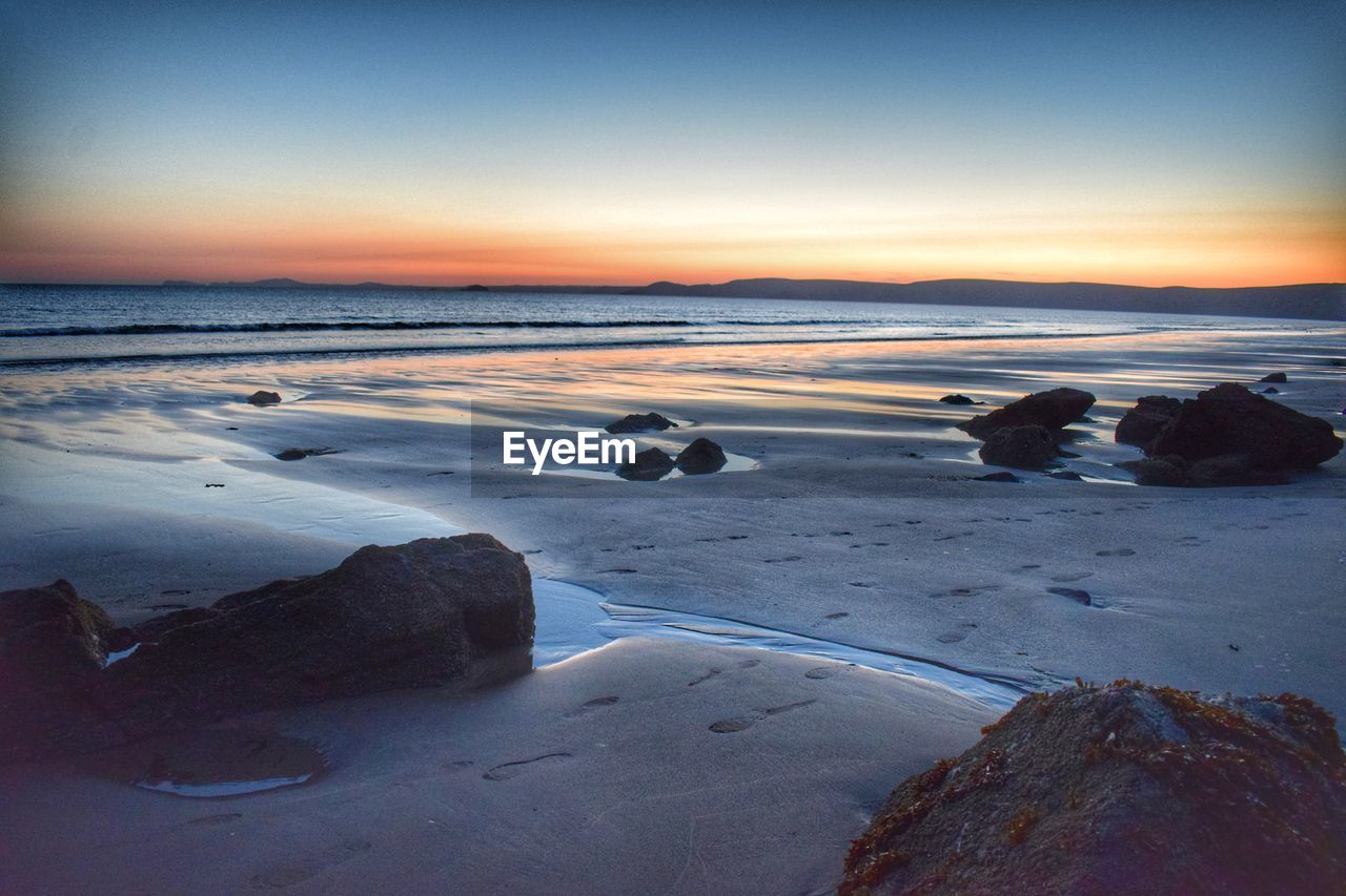 SCENIC VIEW OF BEACH DURING SUNSET