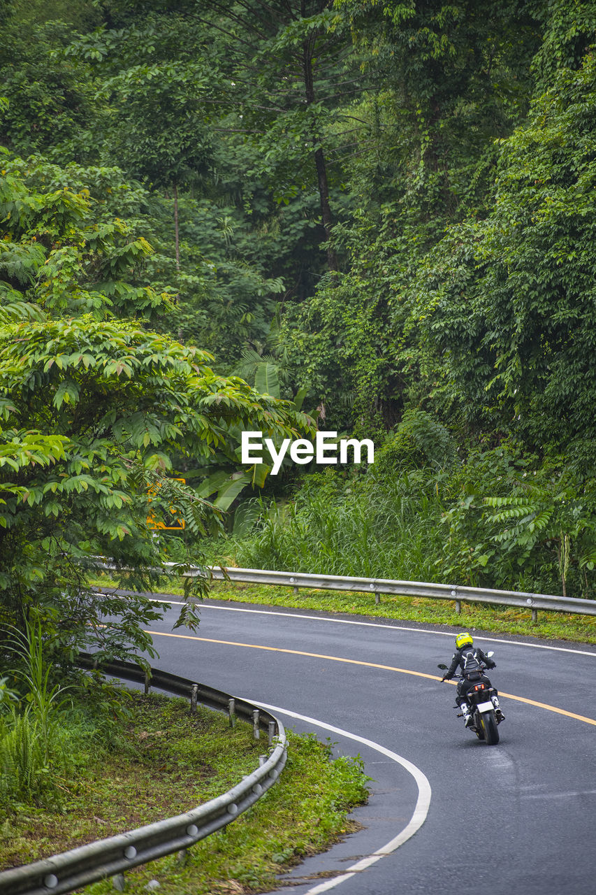 Woamn riding her motorcycle on empty highway in thailand