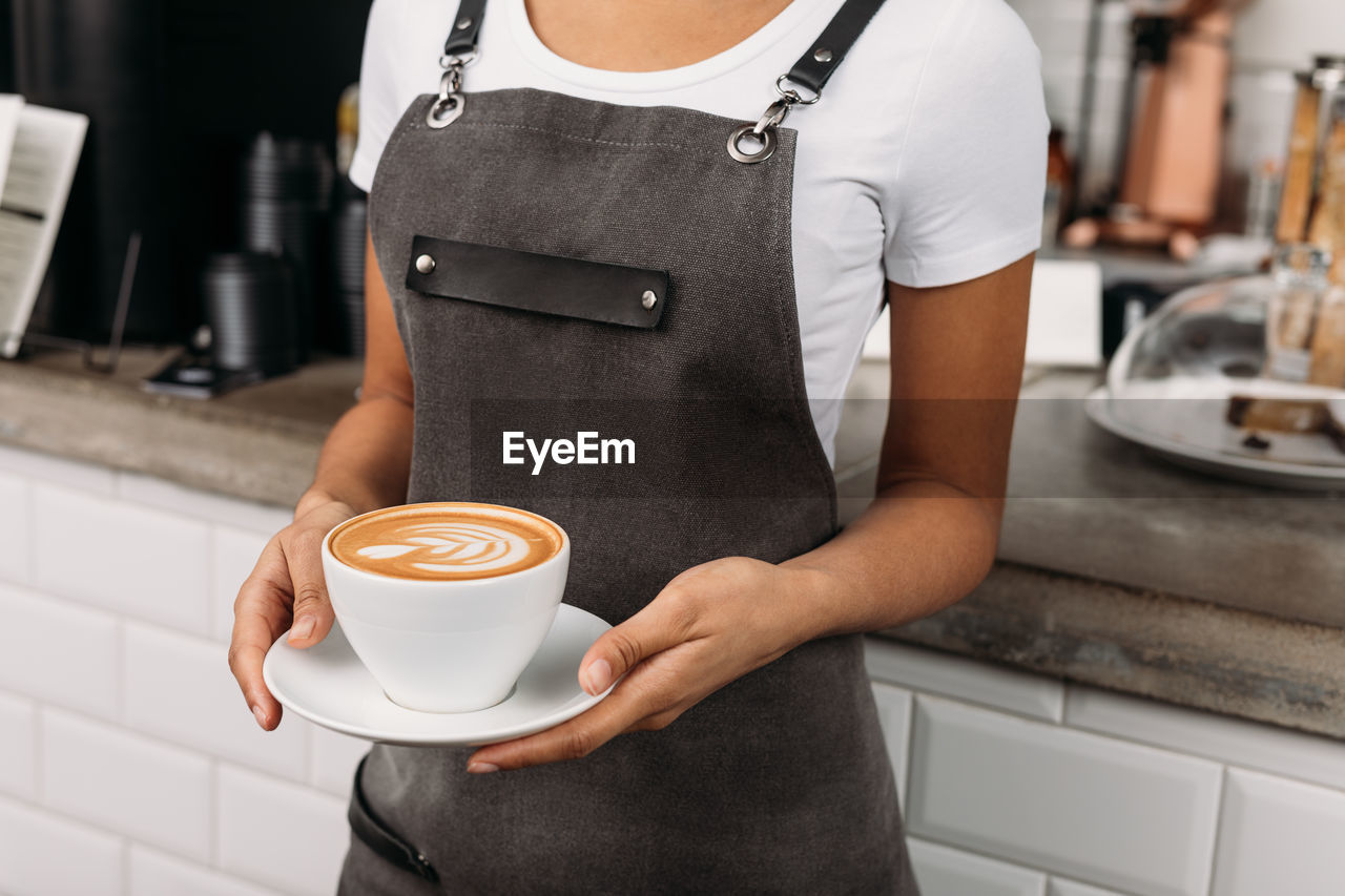 midsection of man holding coffee