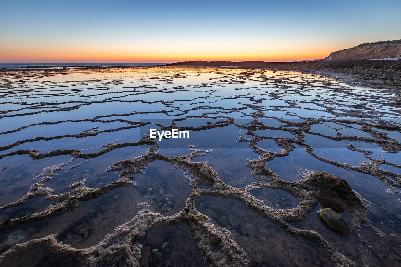 SCENIC VIEW OF BEACH DURING SUNSET