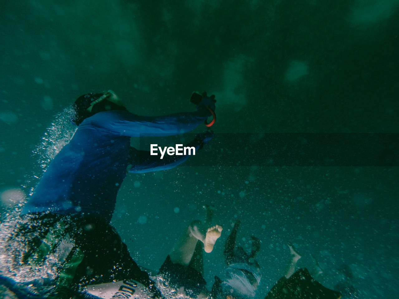 People swimming underwater in sea