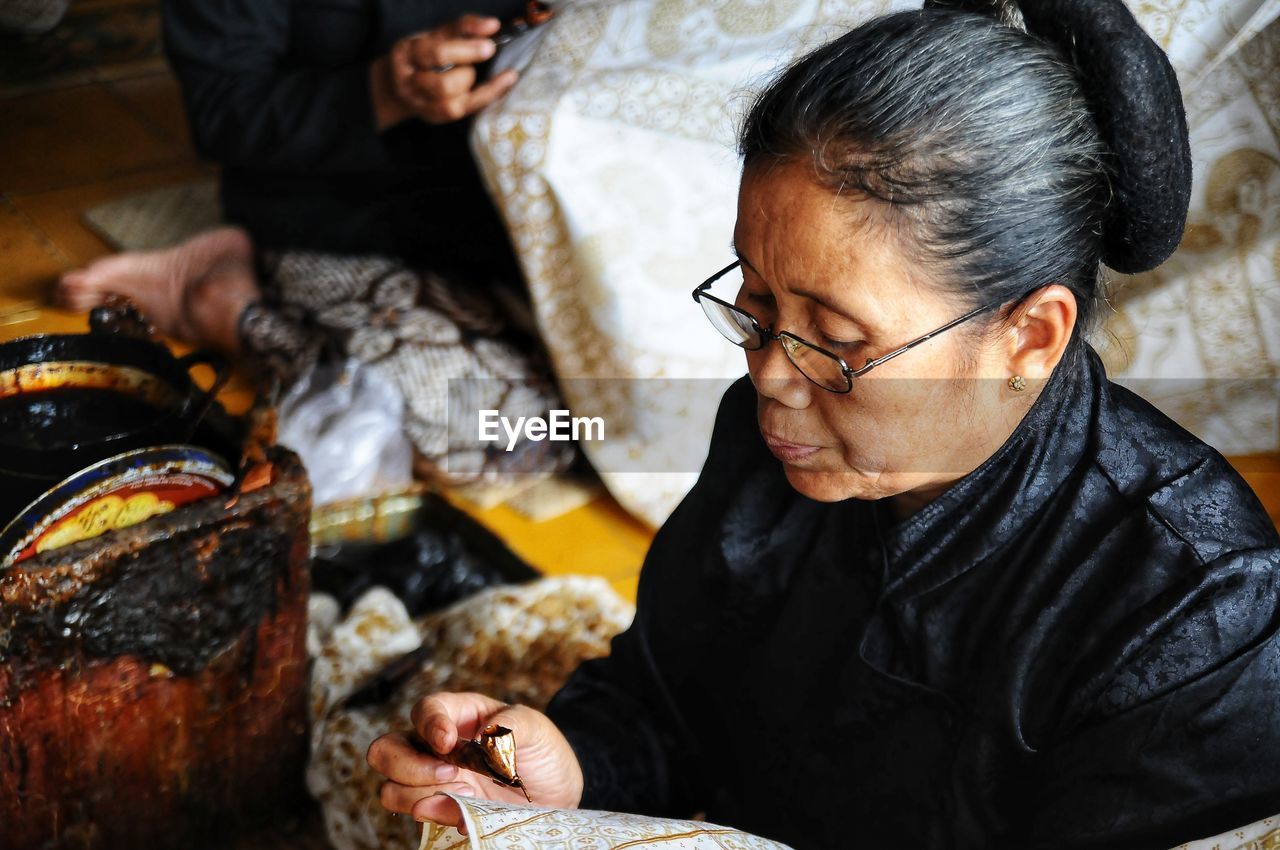 Close-up of mature woman working in factory