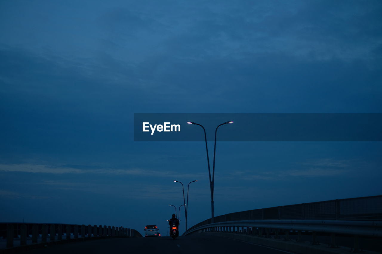 STREET LIGHTS ON ROAD AGAINST SKY