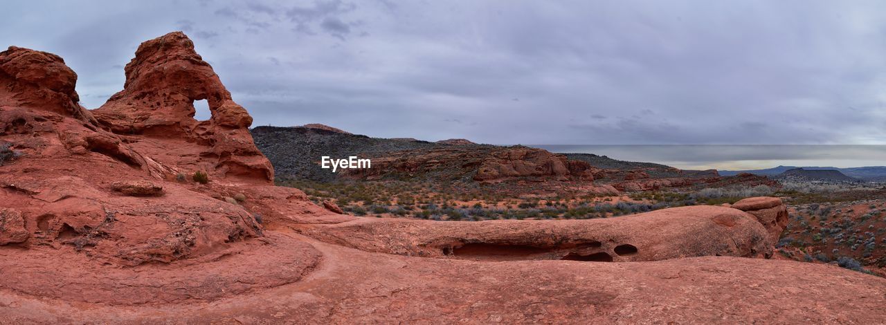 rock, landscape, environment, scenics - nature, sky, cloud, nature, rock formation, beauty in nature, travel destinations, land, mountain, valley, wilderness, desert, travel, natural environment, non-urban scene, geology, no people, climate, semi-arid, tranquility, plateau, outdoors, red, dramatic sky, tourism, extreme terrain, wadi, tranquil scene, arch, arid climate, panoramic, remote, canyon, day, physical geography
