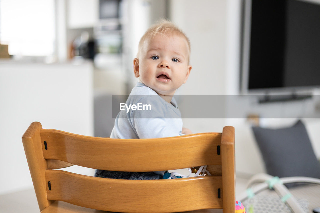 portrait of cute boy sitting on chair