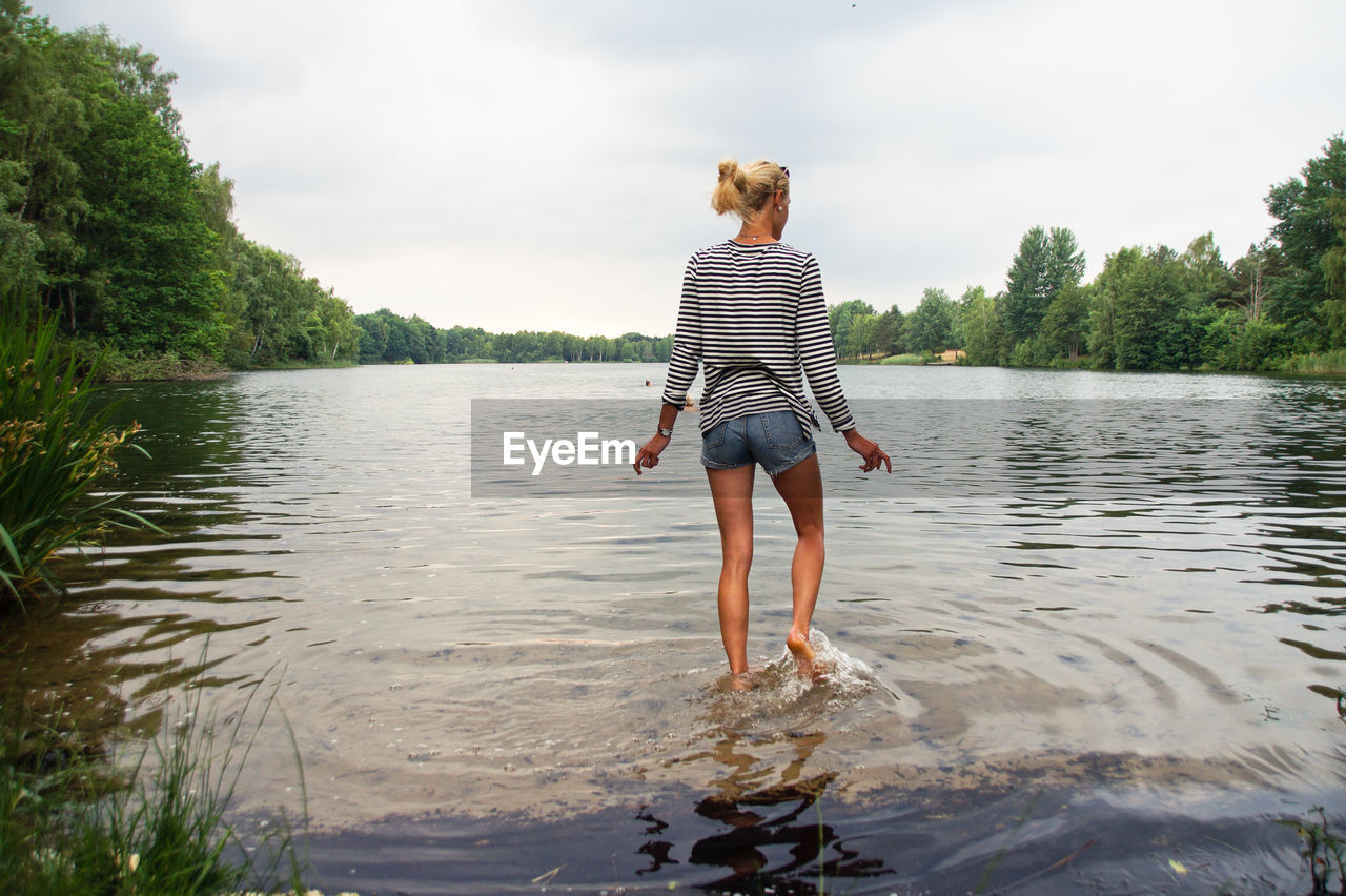 Rear view of young woman walking in lake