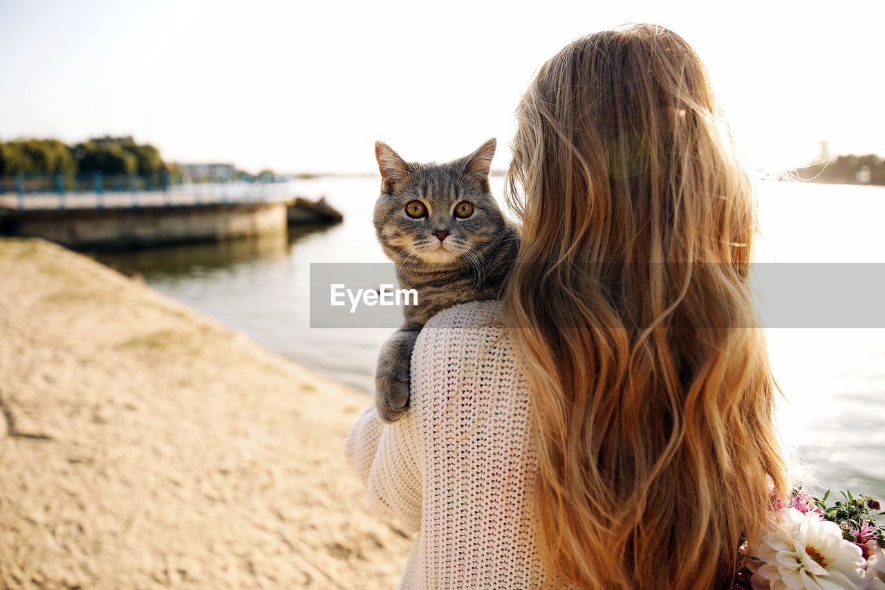 Woman hugging a scottish kitten on a walk