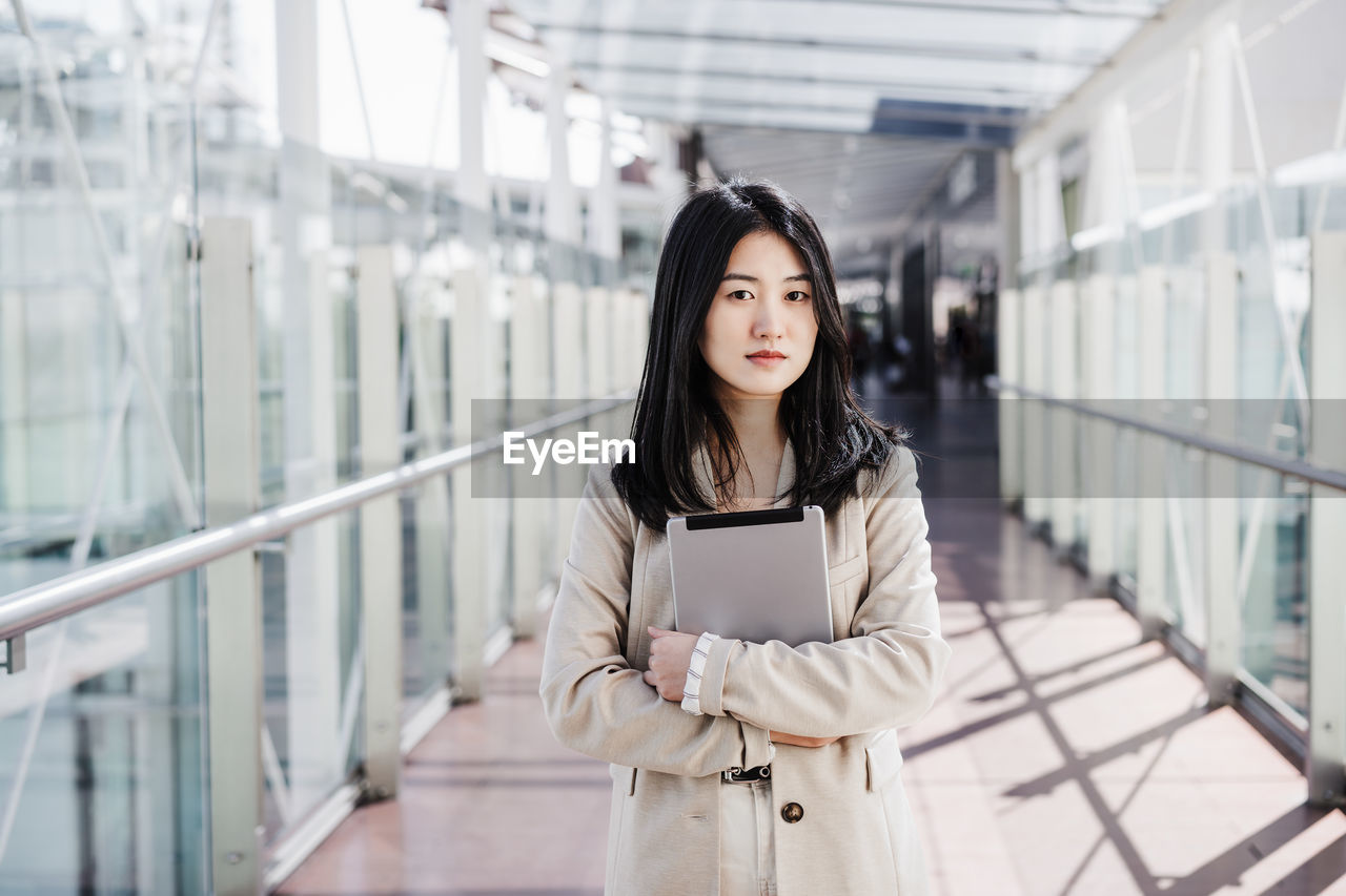 Portrait of beautiful chinese business woman using digital tablet in building office. technology