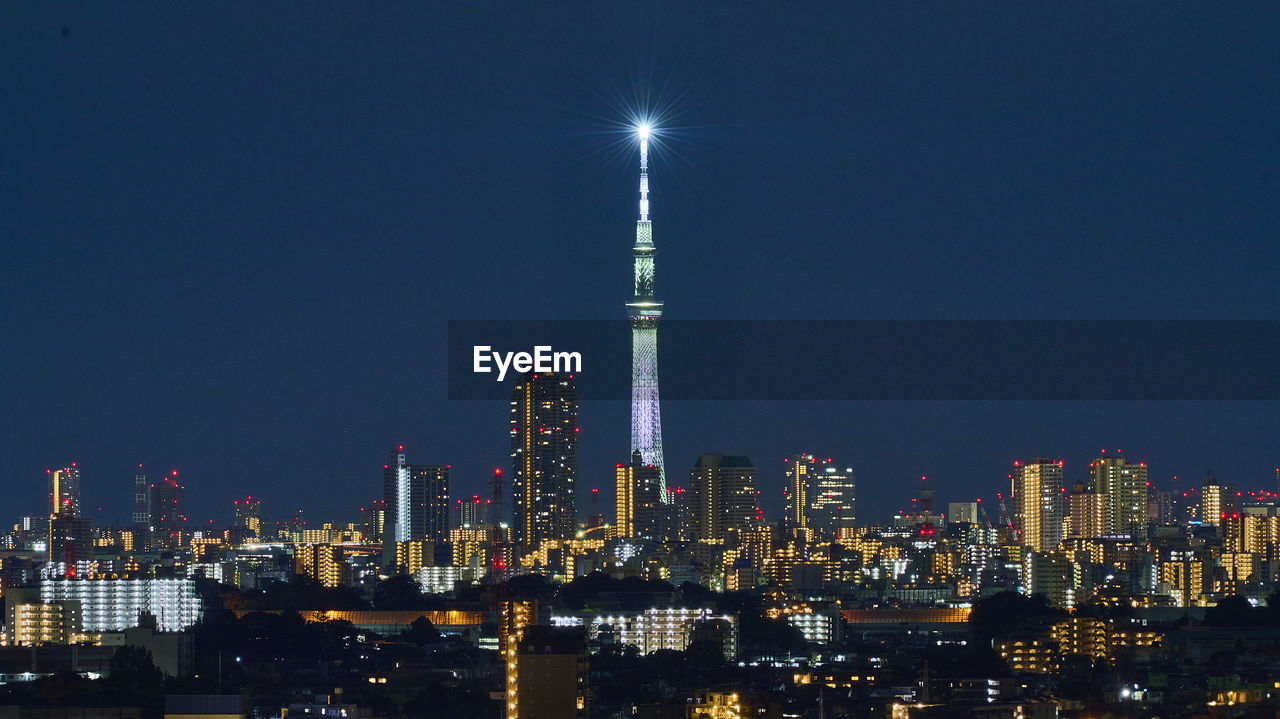 Illuminated buildings against sky at night