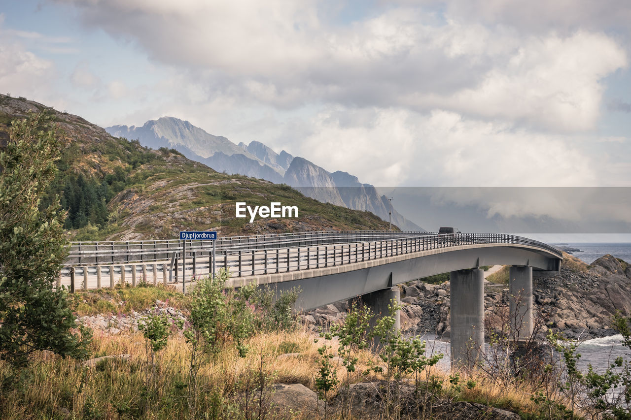 Bridge over mountain against sky