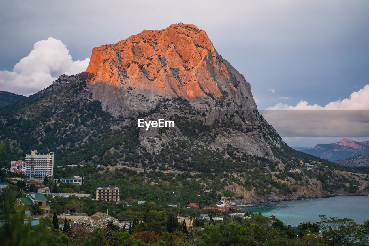 Mount falcon lit by pink sunset in novyi svit during autumn season. sudak, the republic of crimea.