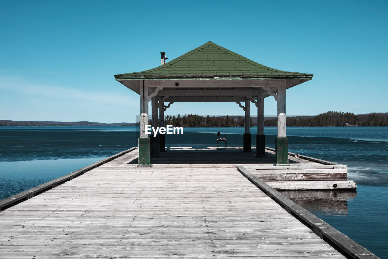 A photograph of a old government dock taken on a sunny warm day during the spring thaw
