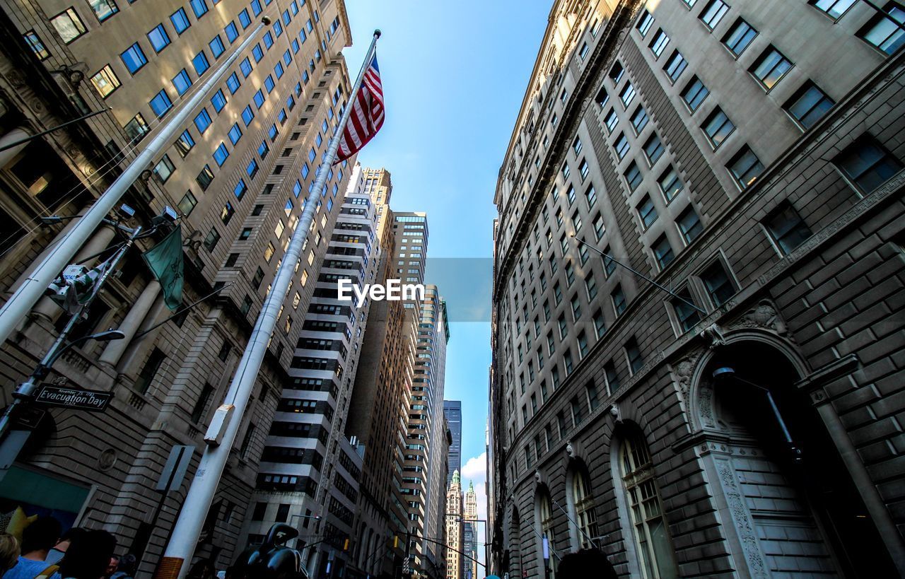 Low angle view of american flag amid buildings against clear sky