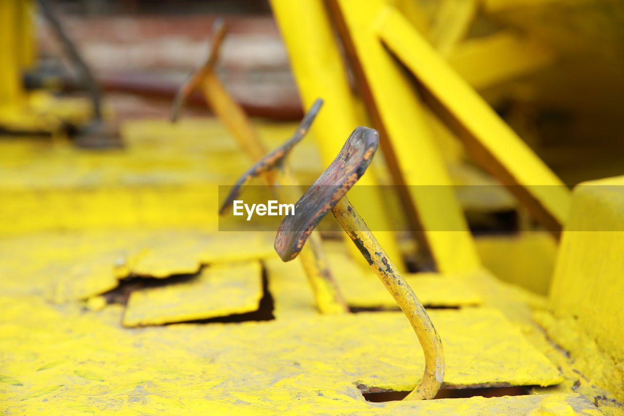 CLOSE-UP OF YELLOW RUSTY METAL