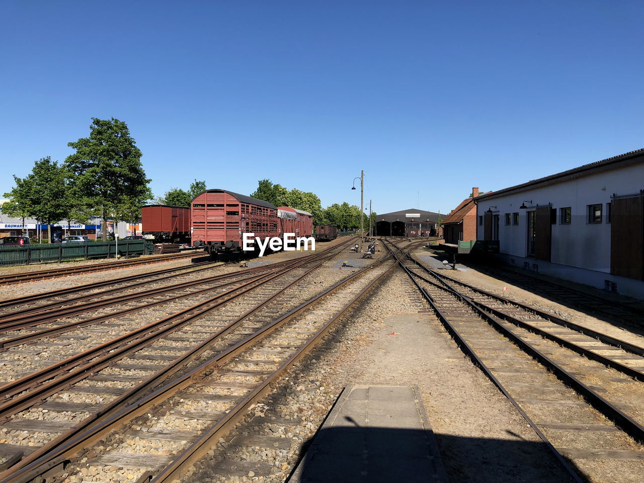 RAILROAD TRACKS BY BUILDINGS AGAINST SKY