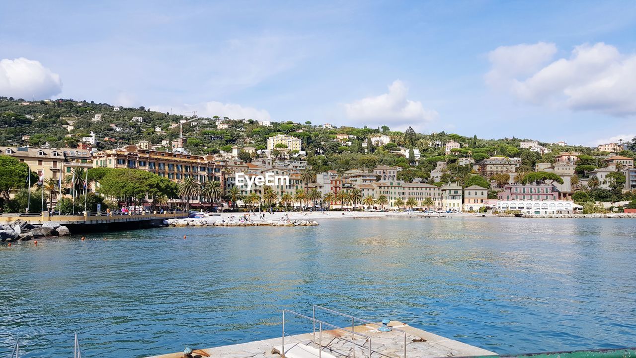 View of townscape by sea against sky