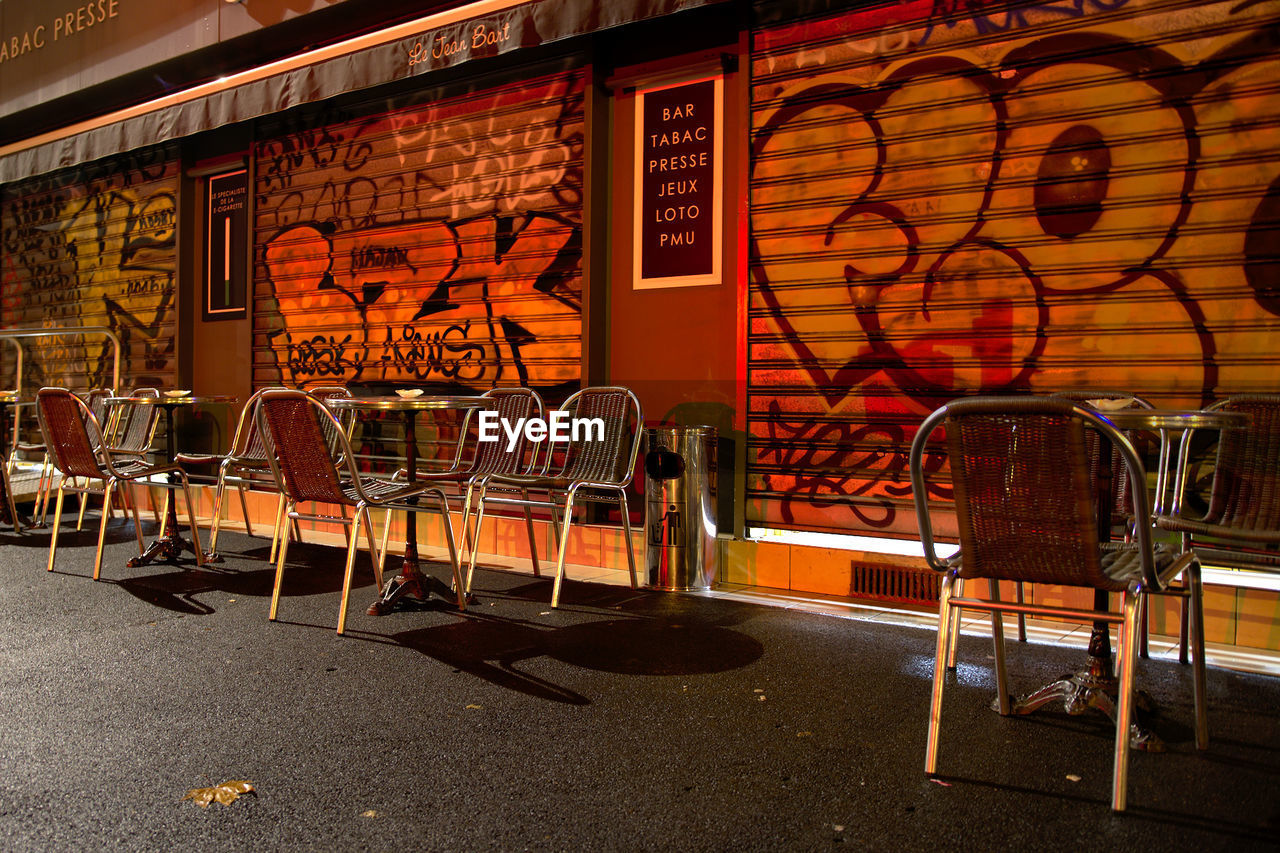 EMPTY CHAIRS AND TABLES AGAINST WALL