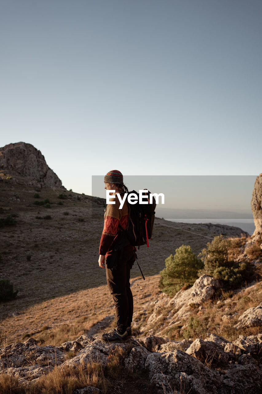 Full length of man standing on rock against sky