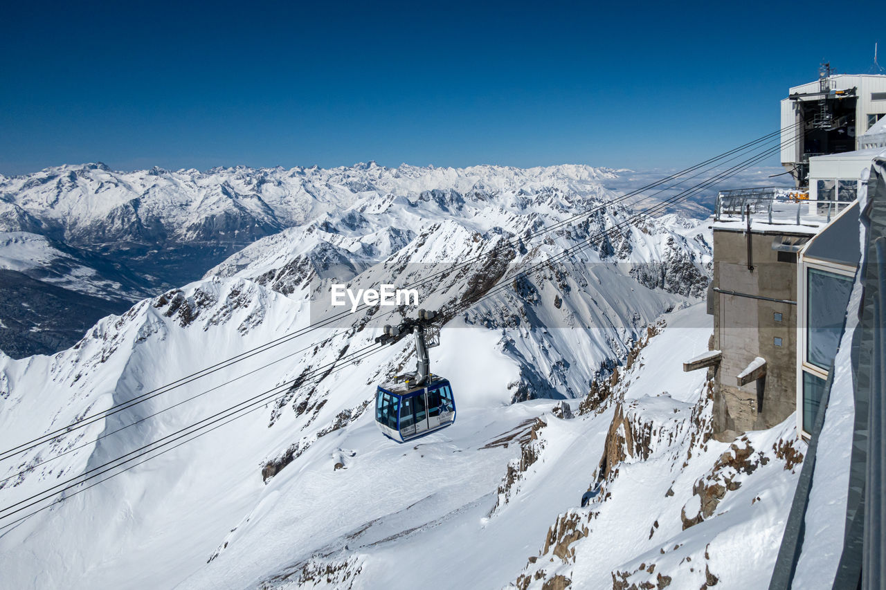 Cable car scenic view of snowcapped mountains against clear blue sky