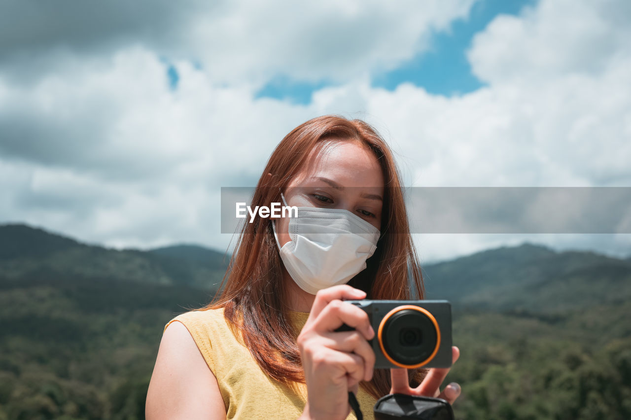 Young woman traveller using her camera