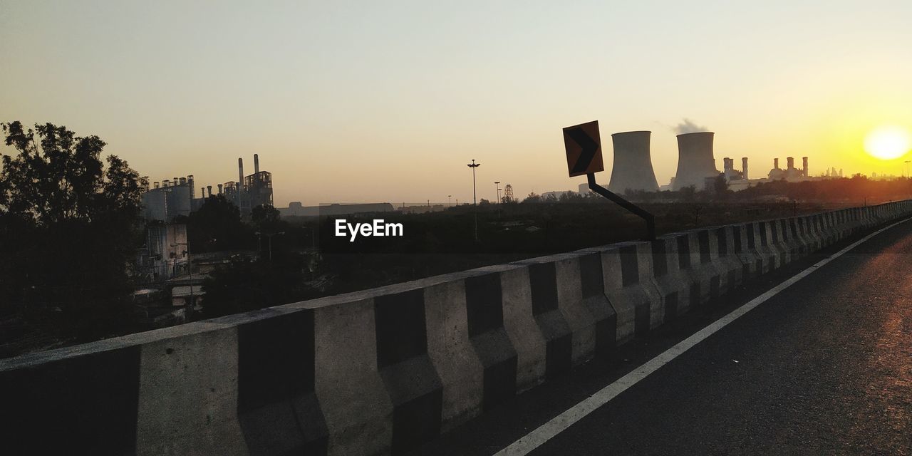 VIEW OF CITY STREET AGAINST SKY DURING SUNSET