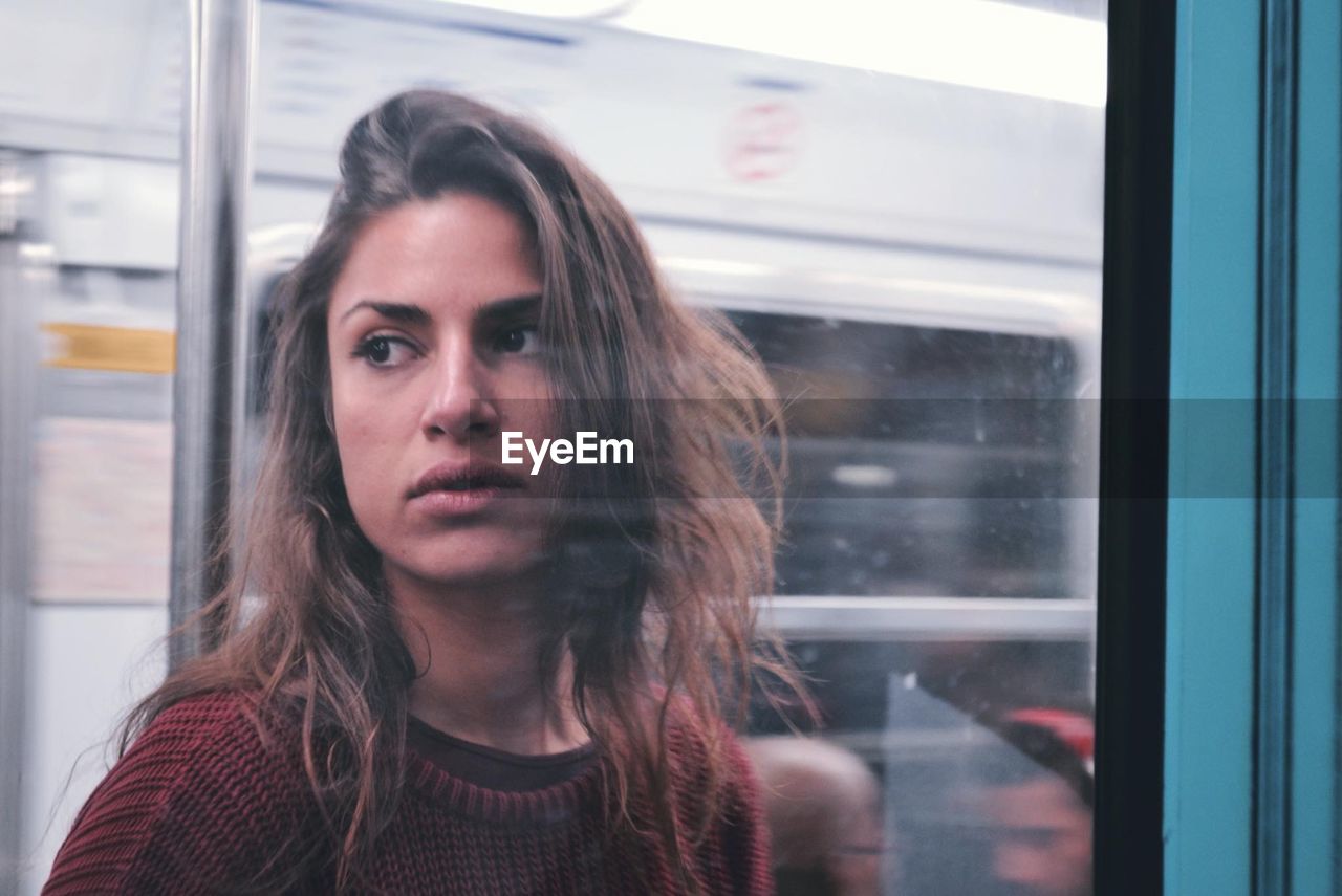 Close-up of young woman looking through train window