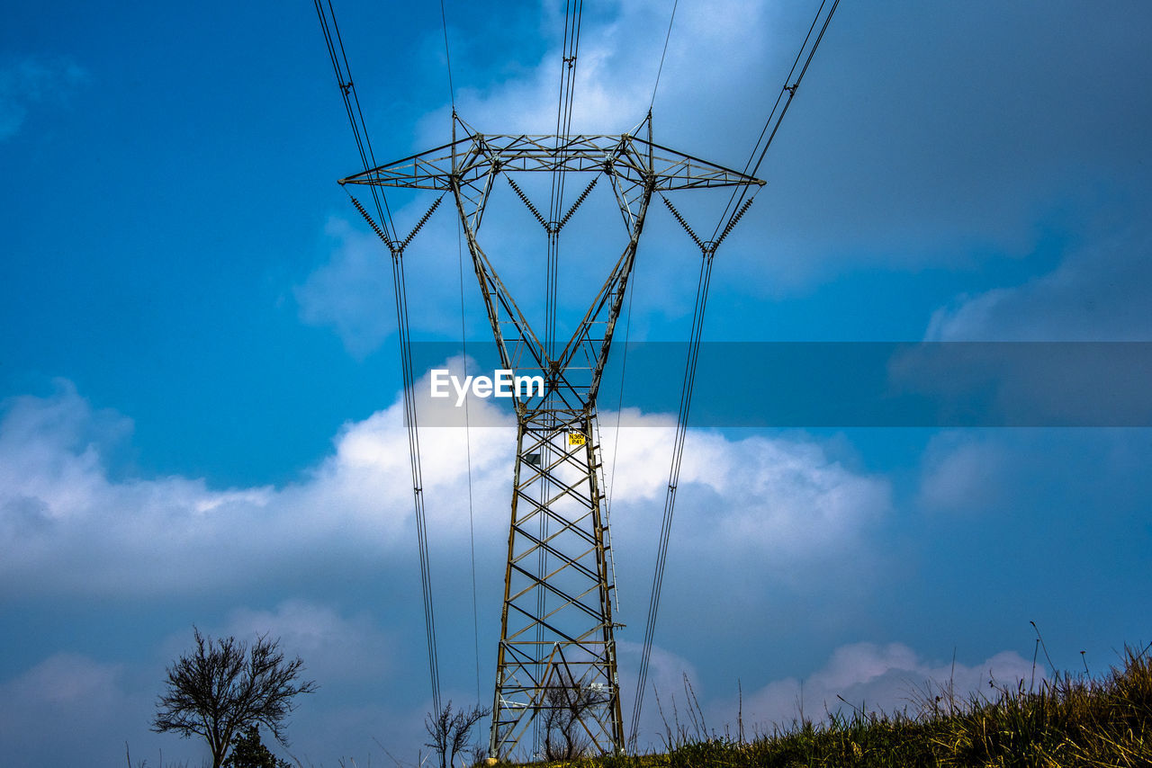 High voltage pylon with blue sky and white clouds
