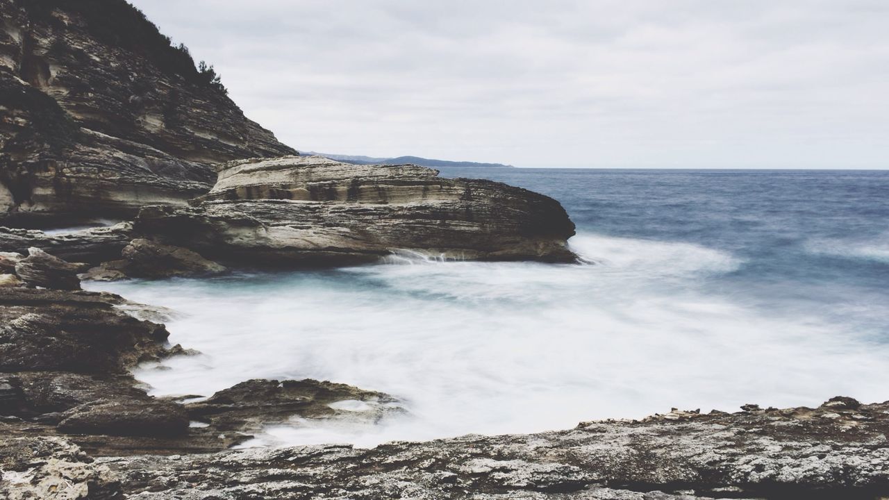 Scenic view of rocks and sea against sky