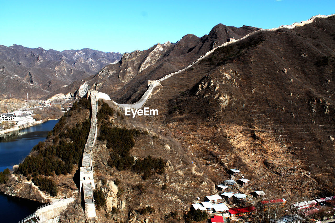 Scenic view of mountain range with the great wall of china against sky