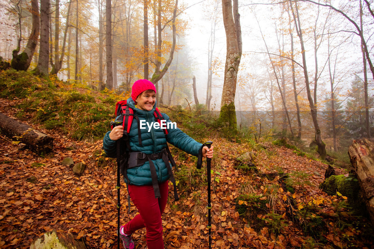 PORTRAIT OF SMILING WOMAN IN FOREST