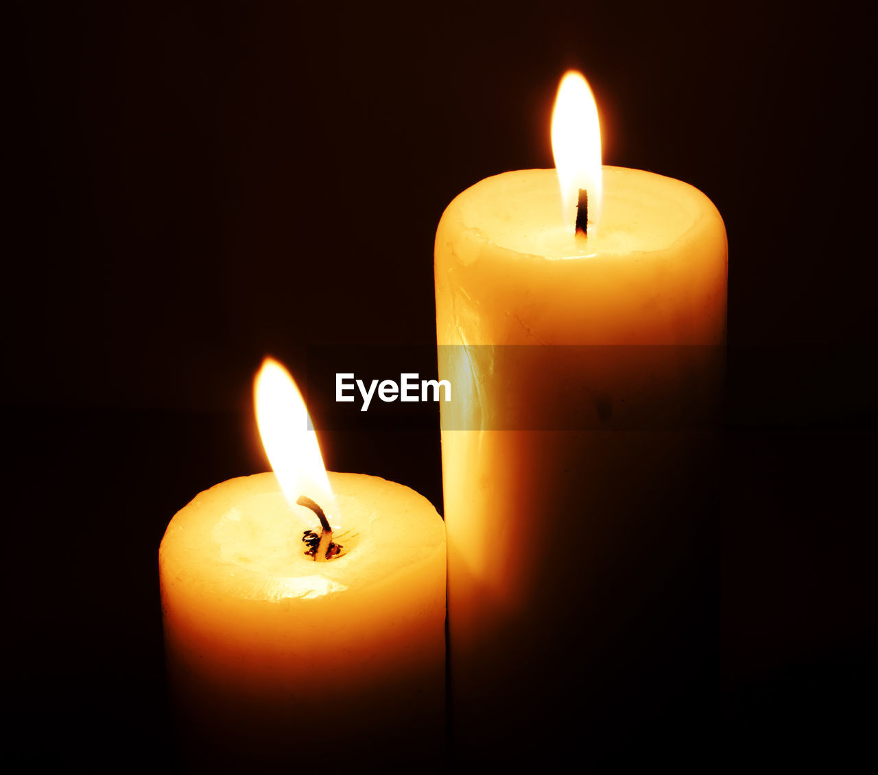 Close-up of lit candles against black background