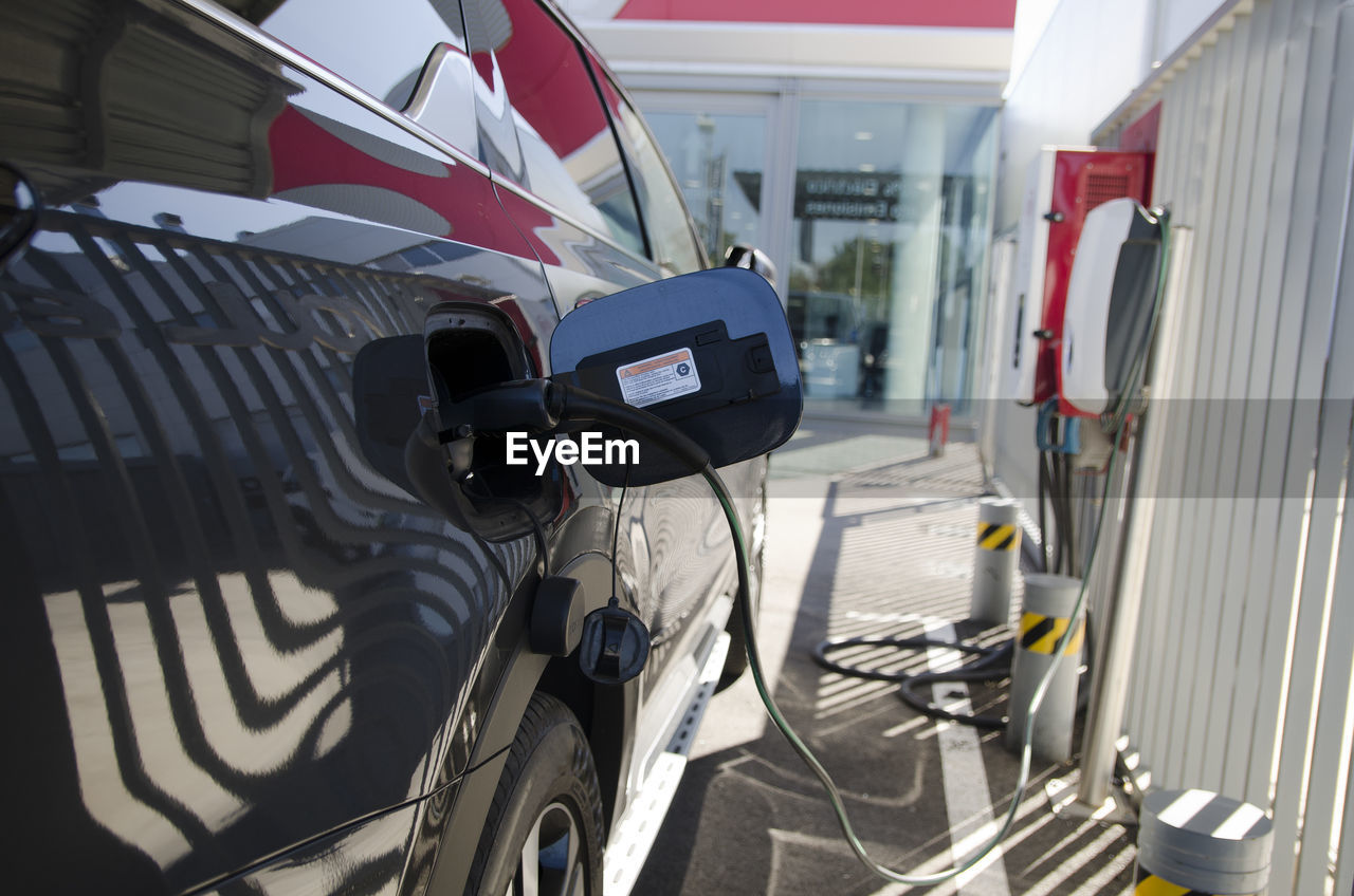 Close-up modern electric commercial van car plugged with fast charger at charging station. eco 