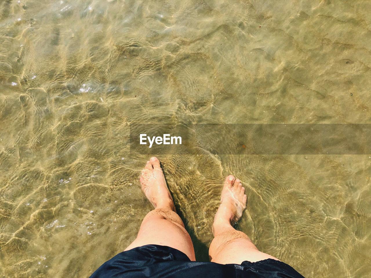 low section, human leg, water, one person, sand, personal perspective, high angle view, lifestyles, nature, leisure activity, beach, barefoot, sea, land, vacation, human foot, trip, day, adult, holiday, sunlight, directly above, standing, relaxation, outdoors, limb, rippled, human limb, shoe, women, wet, men, summer, tranquility, shallow