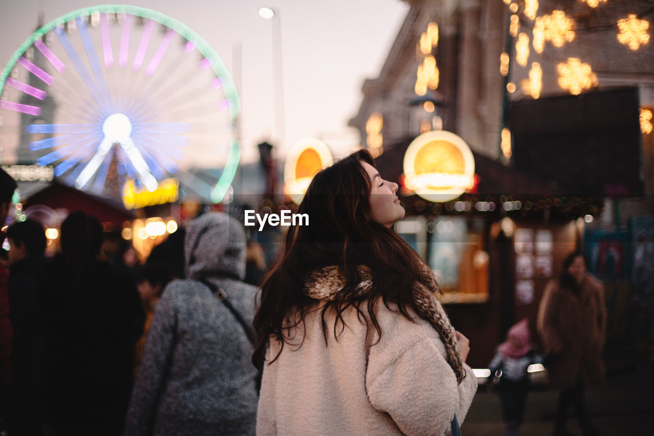 Happy teenage girl enjoying city while walking in christmas market