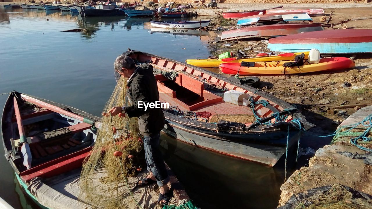 HIGH ANGLE VIEW OF ABANDONED BOAT MOORED AT SHORE