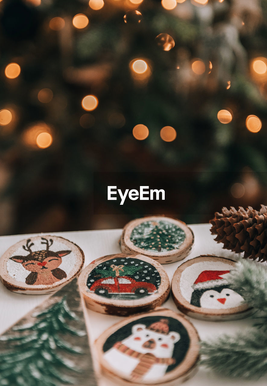 Diy wooden christmas ornaments on table in front of christmas tree