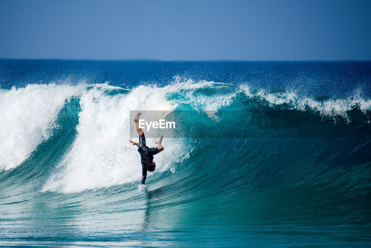 MAN SURFING ON SEA