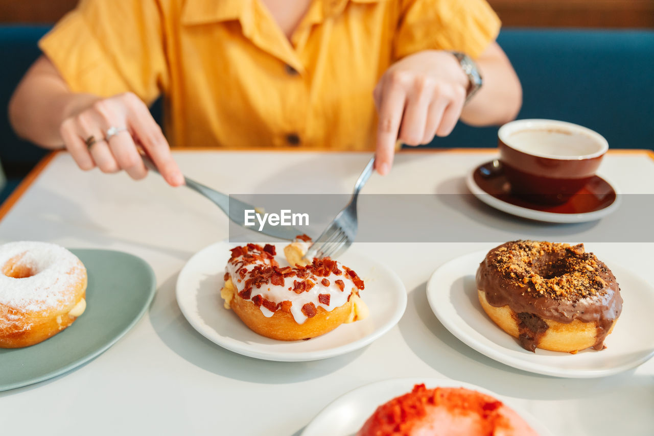 Midsection of woman eating food at restaurant