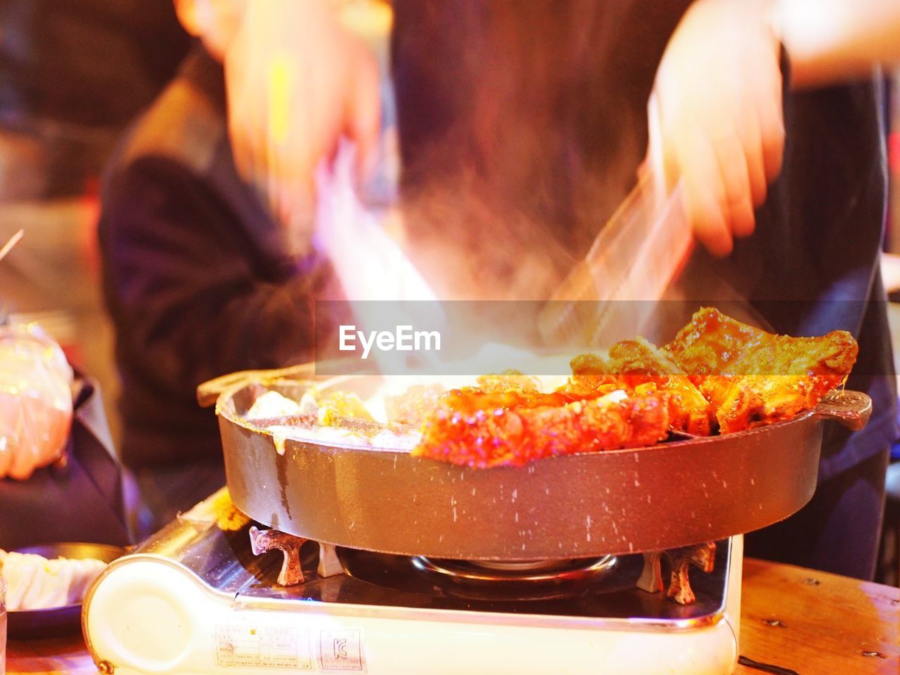 CLOSE-UP OF PREPARING FOOD ON GRILL