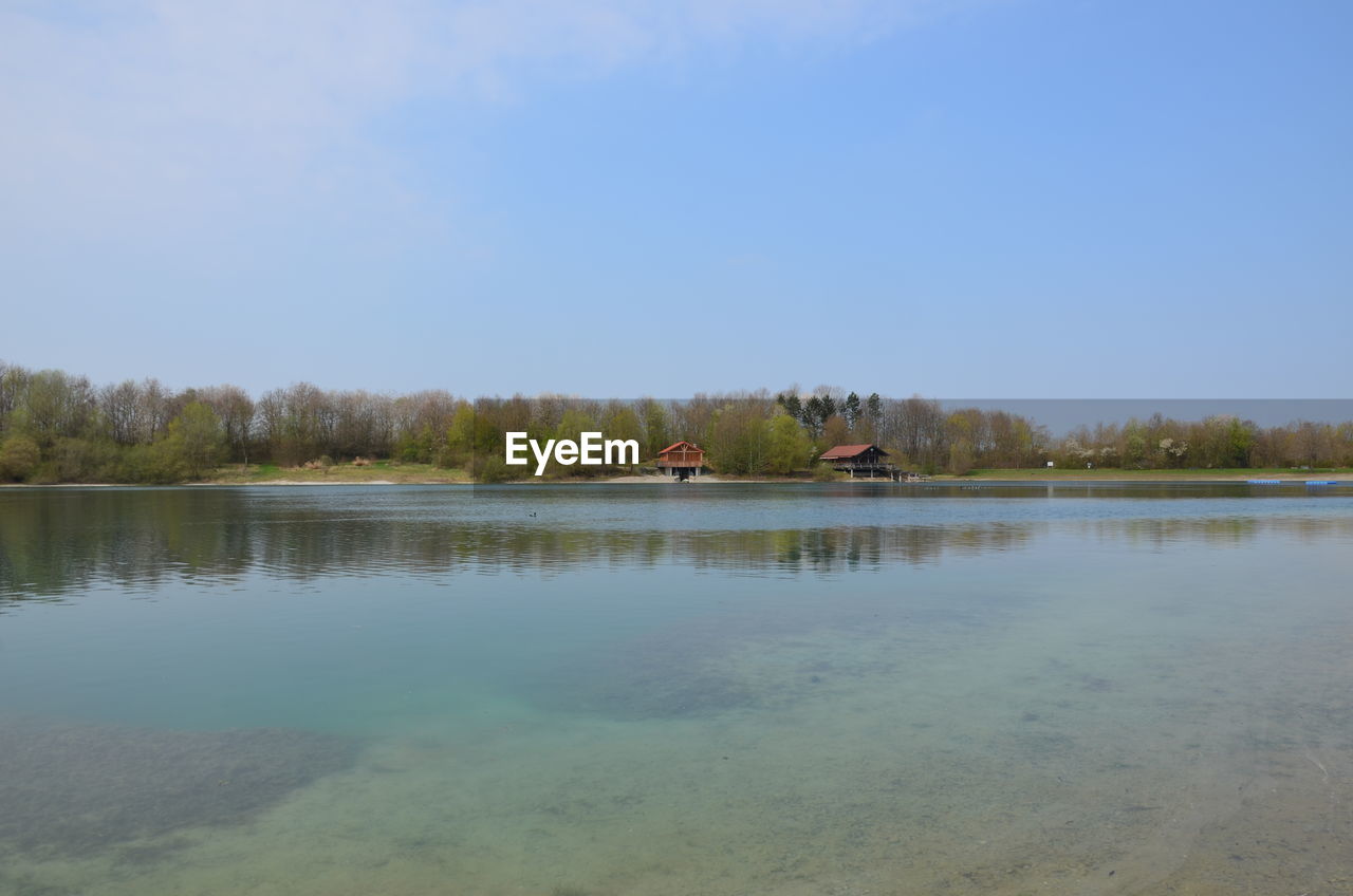 PEOPLE IN LAKE AGAINST SKY