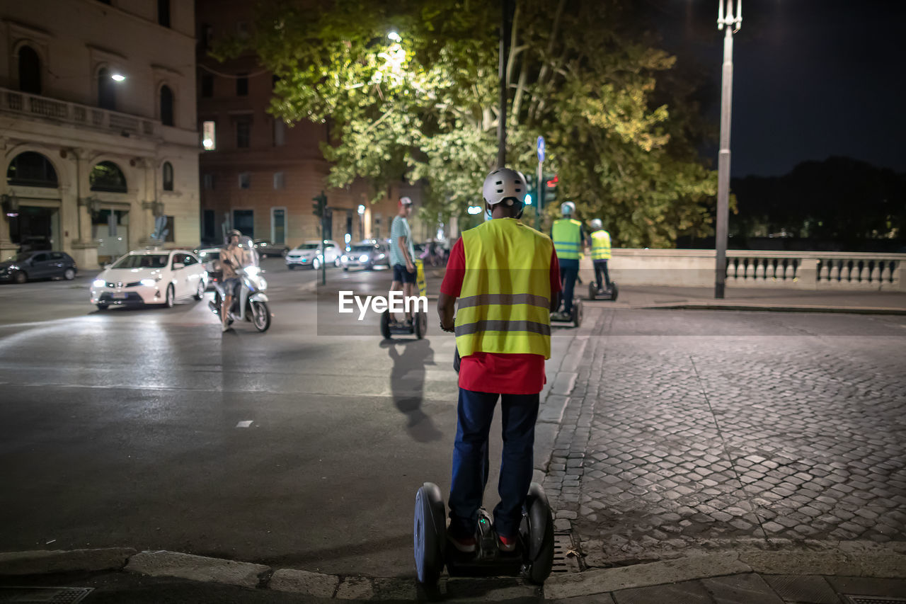 REAR VIEW OF MEN STANDING ON STREET