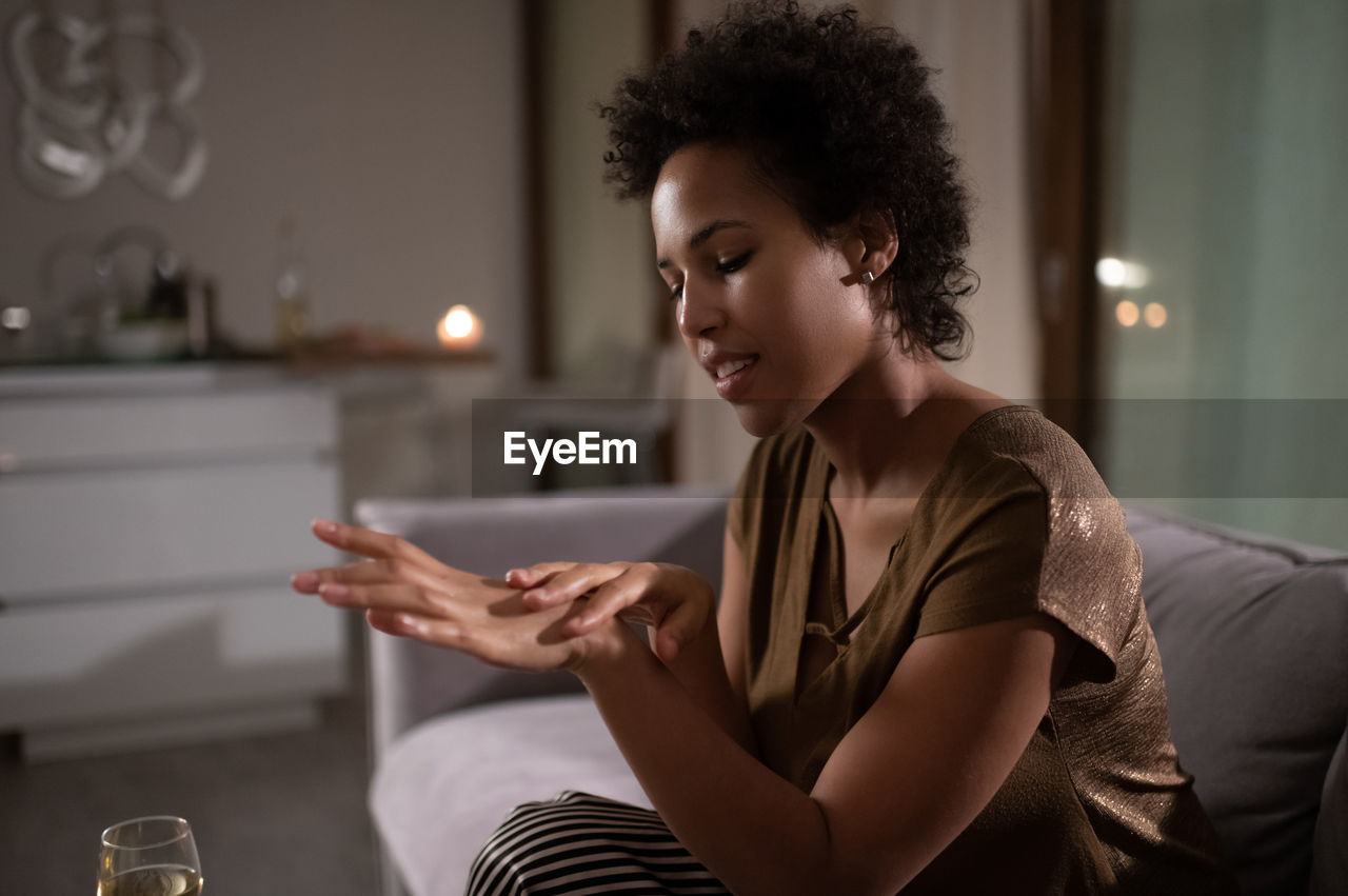 Black woman applying cream on hands