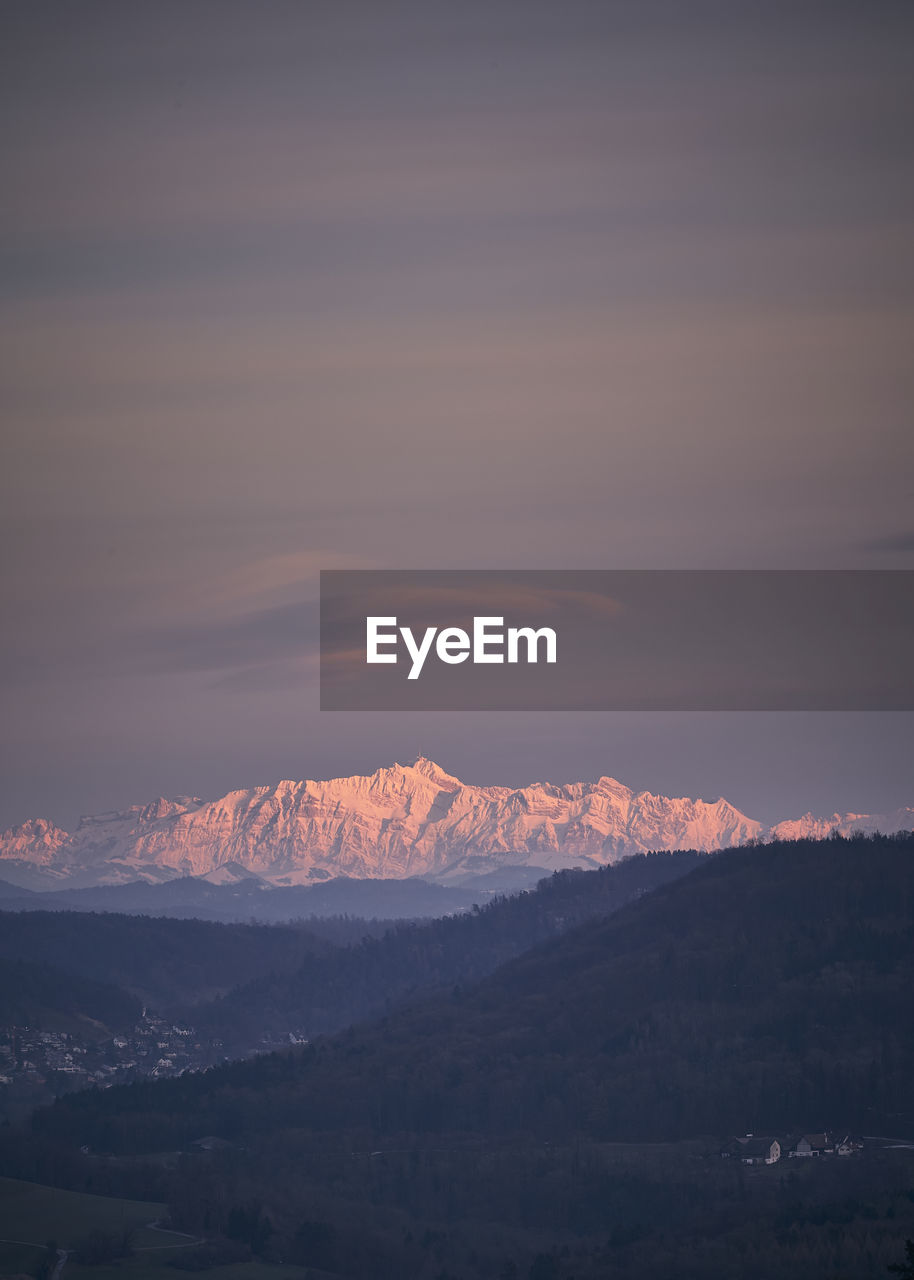 Scenic view of snowcapped mountains against sky during sunset