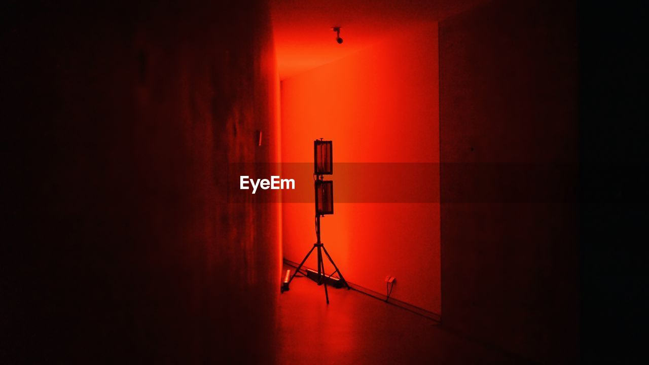 Lighting equipment against red wall in darkroom