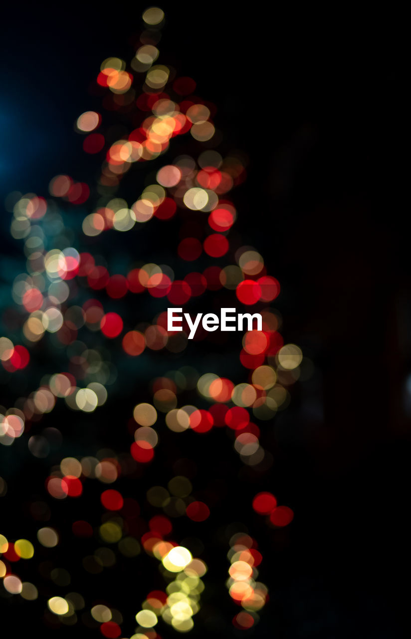 Defocused image of illuminated christmas tree at night